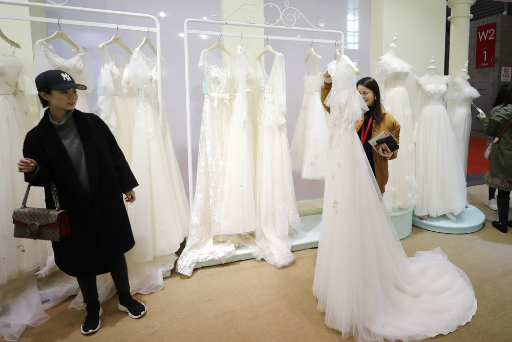 图为来自全国各地的客商及顾客在寻觅合适的婚纱礼服。.jpg